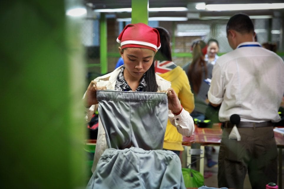 A garment worker checks pants in a factory in Cambodia on December 9, 2014 (ILO)