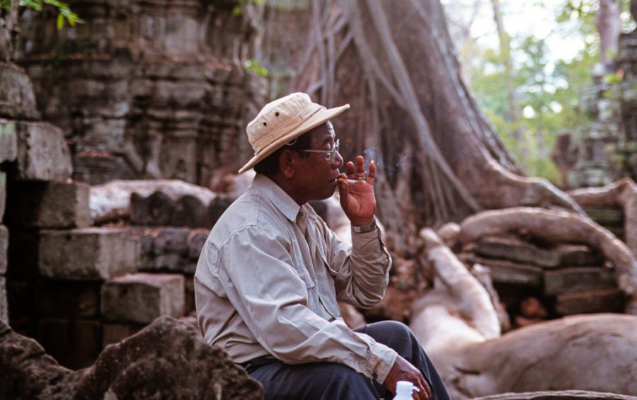 Musician Yoeun Mek smokes a cigarette at the Angkor Archaeological Park in April 1999. (Alan Morgan/Creative Commons)