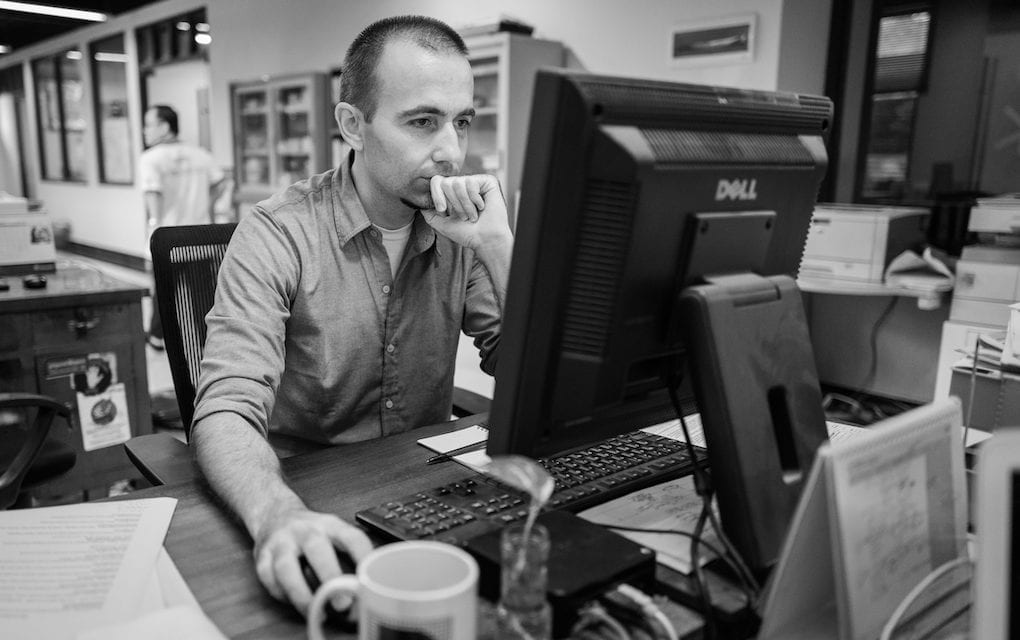 Zsombor Peter, a former Cambodia Daily associate editor, works at his computer in the newsroom in Phnom Penh on September 3, 2017, when staff produced the final issue of the newspaper. (Ben Woods)