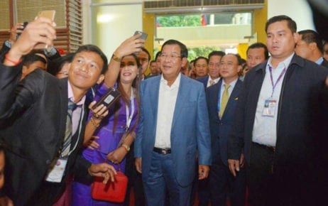 Prime Minister Hun Sen poses for photos with journalists invited to a ‘solidarity dinner’ in Phnom Penh on January 11, 2019. (Agence Kampuchea Presse)