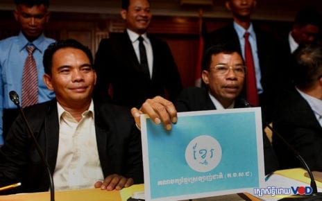Kheuy Sinoeun, right, holds up a sign with the Cambodia Nation Love Party’s name, in Phnom Penh on January 2, 2020. (Panha Chhorpoan/VOD)