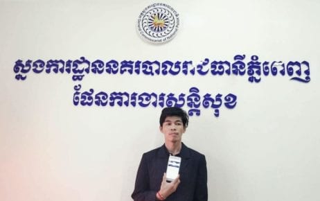 Sovann Rithy, editor of the TVFB news site, holds up a smartphone at the Phnom Penh Municipal Police Headquarters following his arrest on April 7, 2020. (Phnom Penh Municipal Police)
