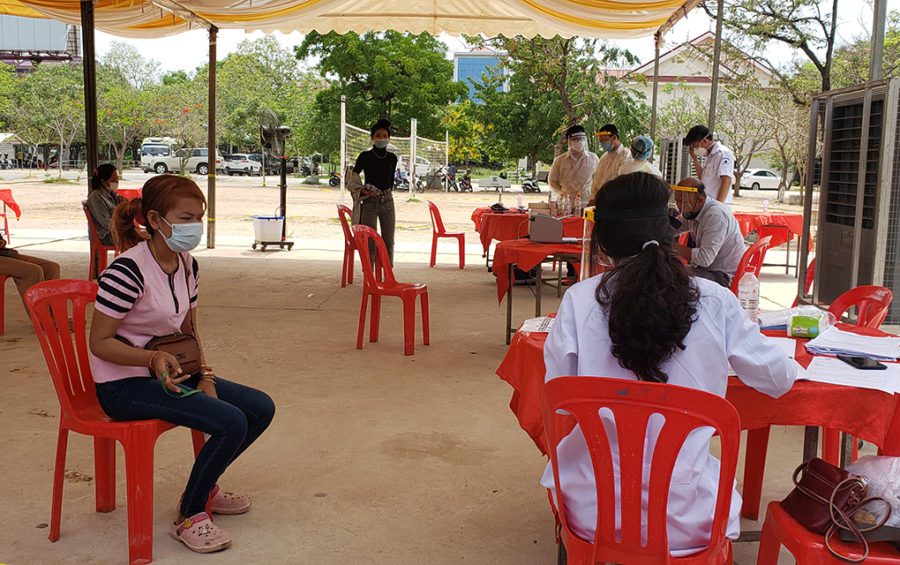 A doctor speaks with a worker at a health checkup site at Chumpouvoan High School in Phnom Penh on April 20, 2020. (Danielle Keeton-Olsen/VOD)