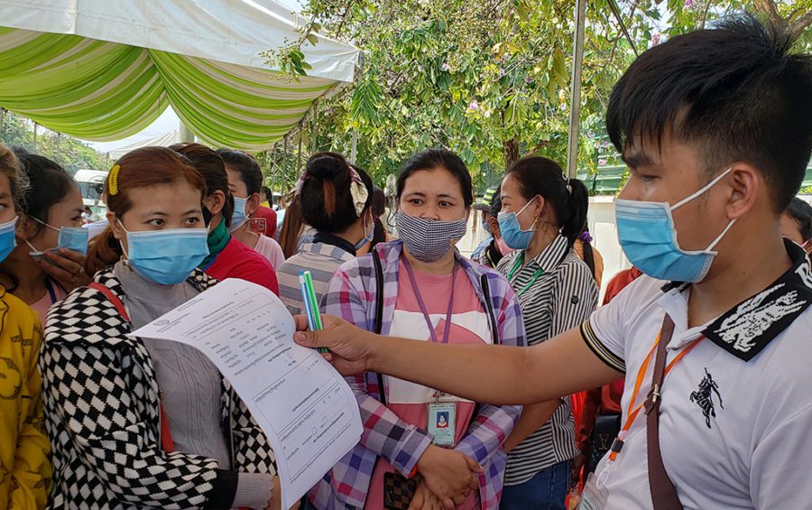 Hun Sokhun, a human resources officer at the Southland (Cambodia) garment factory in Phnom Penh, speaks with workers at a health checkup site at Phnom Penh’s Vattanac Industrial Park on April 20, 2020. (Danielle Keeton-Olsen/VOD)