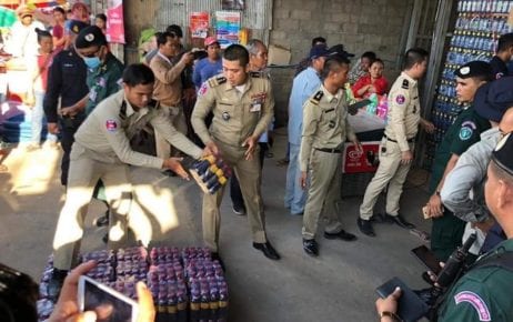 Police collect bottles of a wine product linked to multiple deaths in Banteay Meanchey province on June 11, 2020. (Banteay Meanchey Provincial Police)