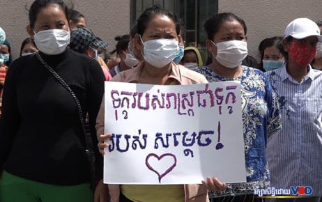 A woman holds a sign saying “The pain of the people is the pain of Samdech [Prime Minister Hun Sen]” as nightlife workers filed a petition to the premier’s cabinet asking for aid on June 25, 2020. (Hy Chhay/VOD)