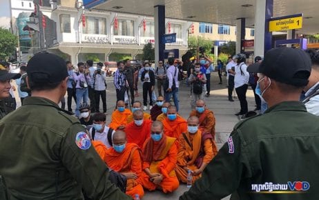 Youth activists and monks sit and chant in a memorial ceremony on July 8, 2020 near the Caltex gas station in Phnom Penh where political analyst Kem Ley was murdered four years ago. (Chorn Chanren/VOD)