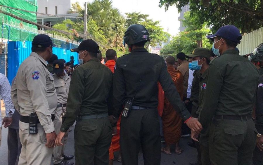 Chamkarmorn district security guards hold hands to block monks and youth activists who attempted to hold a memorial ceremony on July 8, 2020 for slain political activist Kem Ley at the capital's Caltex gas station where he was killed in 2016. (Saut Sok Prathna/VOD)