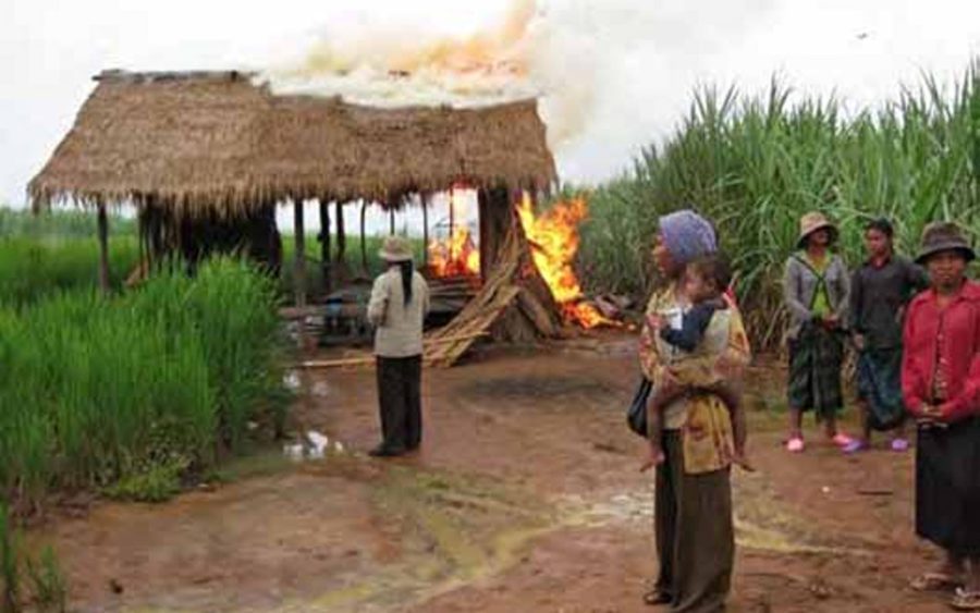 Villagers watch a farmhouse burn in Oddar Meanchey province's O'Bat Moan village in 2009. (Licadho)