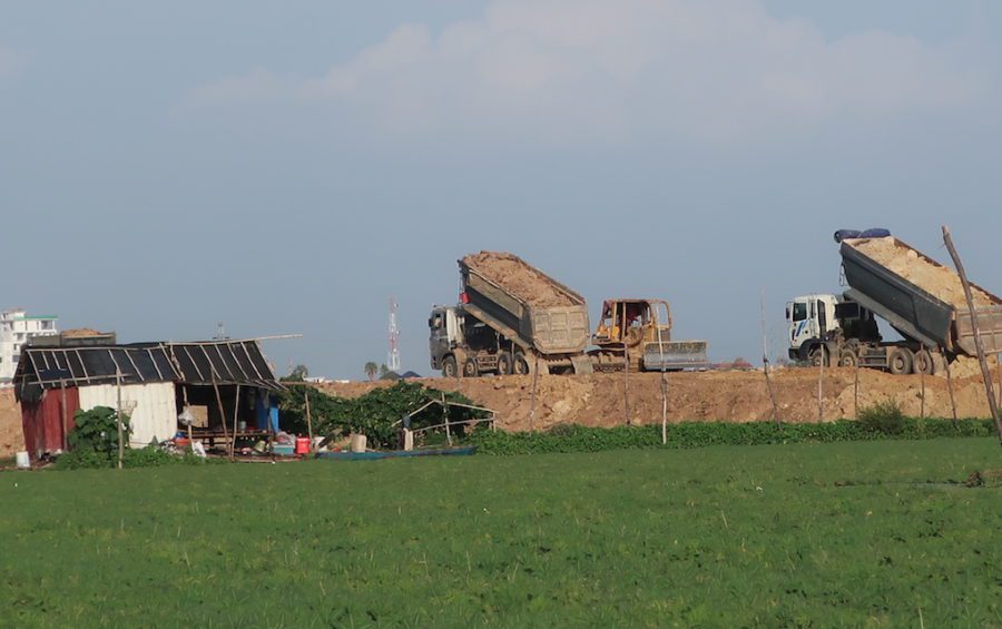 Sand and dirt trucks infilling the lake area near a house to create a road across the wetlands in 2020, near Boeng Choeng Ek (STT)