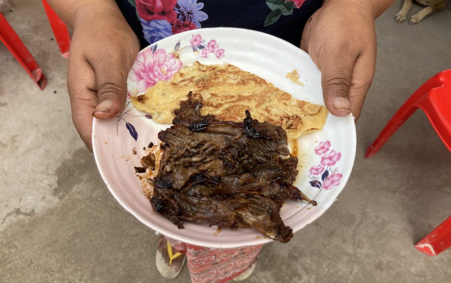 Cheam Nuth, who lives in Takeo’s Koh Andet district, shows reporters her lunch for the day — grilled rat meat and an omelet, on July 30, 2020. (Ananth Baliga/VOD)