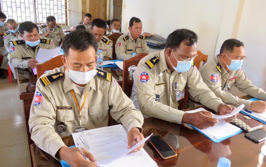 Police officers in Kampong Speu province read documents in this photograph posted to the Immigration Department’s Facebook page on July 31, 2020.