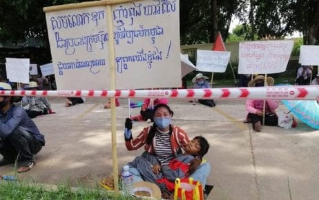 A woman holds a sign during a worker protest at the Cambodian Cultural Village tourism complex in Siem Reap province on August 26, 2020. (Central)