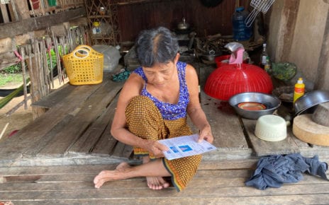 Preh Phnheas resident Chorb Kun looks at her IDPoor and loan documents in August 2020 in Battambang province. (Ananth Baliga/VOD)
