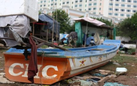 A fishing boat sits on the shore of Phnom Penh’s Chroy Changva with the Sokha Hotel in the background, on September 15, 2020. (Michael Dickison/VOD)