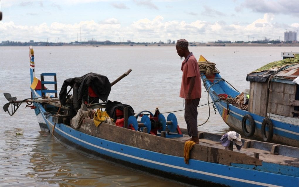 A Cham fisherman stands on his boat on the shore of Phnom Penh’s Chroy Changva, on September 15, 2020. (Michael Dickison/VOD)