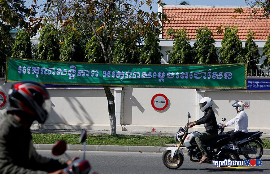 Motorbike drivers pass a sign saying "Thank you for the peace, thank you Samdech Techo Hun Sen" at the Anti-Corruption Unit in Phnom Penh on January 2, 2020. (Panha Chorpoan/VOD)