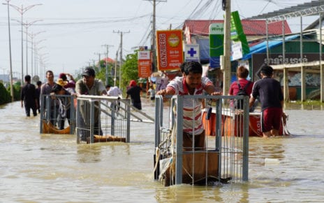 Workers roll a garment factory’s carts through floodwaters in Phnom Penh’s Dangkao district on October 22, 2020. (Tran Techseng/VOD)