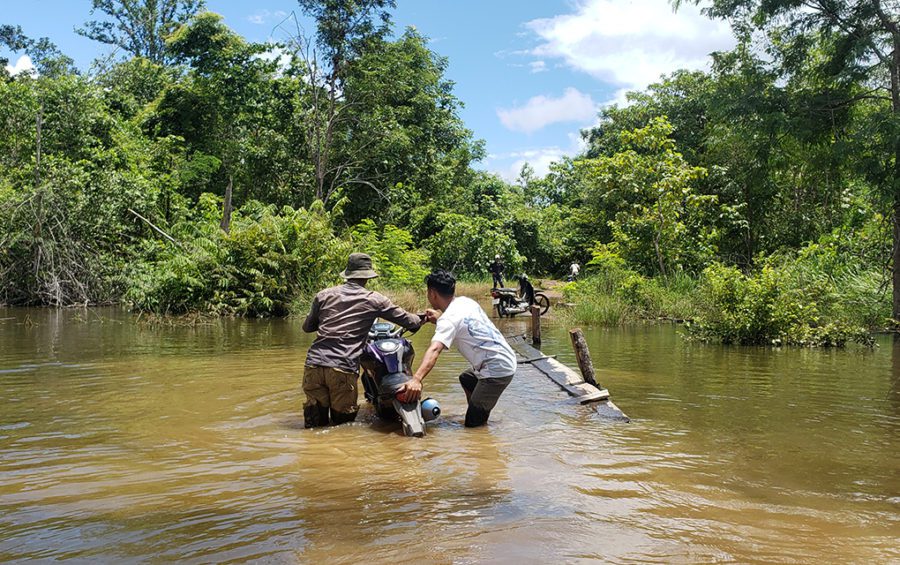 Residents of Old Kbal Romeas pull their motorbikes through flooded waters to reach their ancestral land in Stung Treng province on September 22, 2020. (Danielle Keeton-Olsen/VOD)