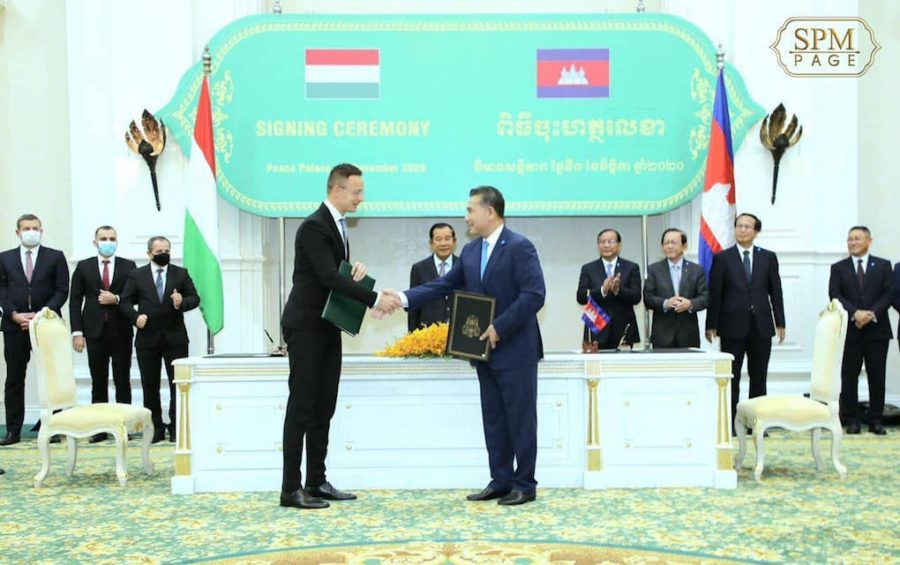 Hungarian Foreign Minister Peter Szijjarto shakes hands with Minister in Charge of Civil Aviation Mao Havannall at a signing ceremony in Phnom Penh on November 3, 2020, as Prime Minister Hun Sen and other officials look on, in this photograph posted to Hun Sen's Facebook page.