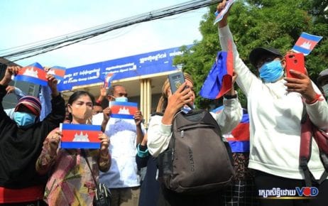 Supporters of the outlawed opposition CNRP hold up Cambodian flags near the Phnom Penh Municipal Court on November 26, 2020. (Chorn Chanren/VOD)