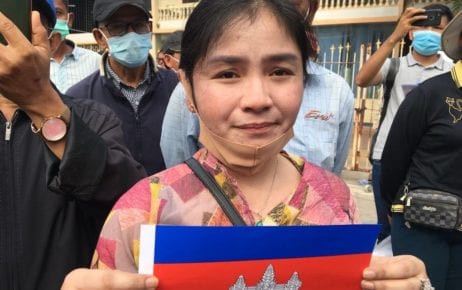 Sin Chanpeou Rozeth, a former CNRP commune chief in Battambang province, holds up a small Cambodian flag outside the Phnom Penh Municipal Court on November 26, 2020.