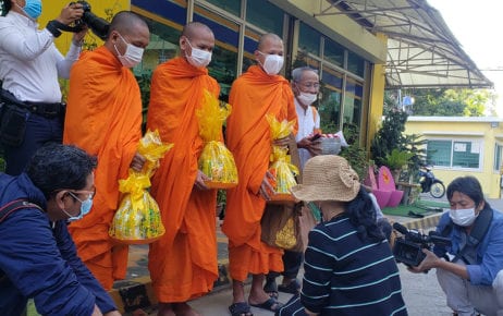 Sitanan Satsaksit kneels before Buddhist monks during a ceremony on December 4, 2020, the six-month anniversary of her brother Wanchalearm Satsaksit's disappearance in Phnom Penh. (Danielle Keeton-Olsen/VOD)