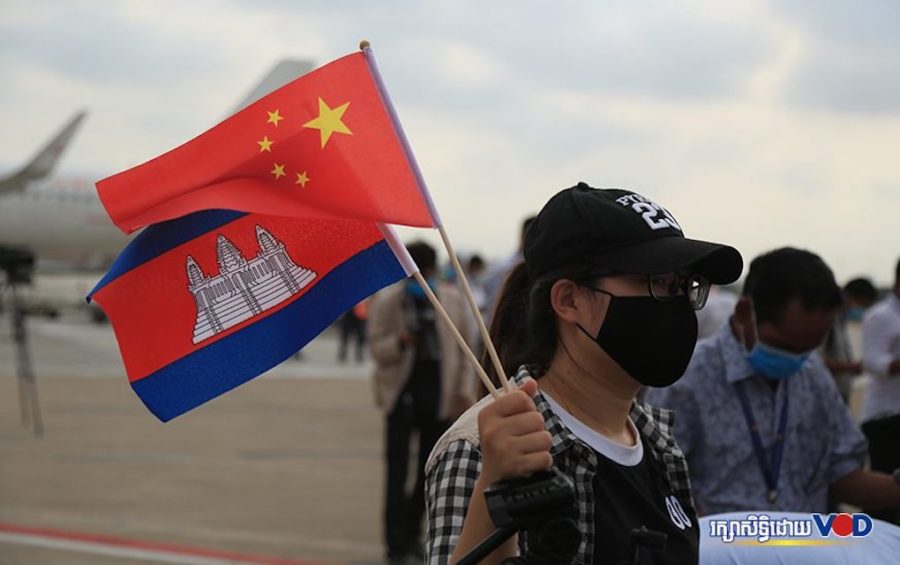 A woman waves the Cambodian and Chinese flags at the Phnom Penh International Airport on March 23, 2020. (Chorn Chanren/VOD)