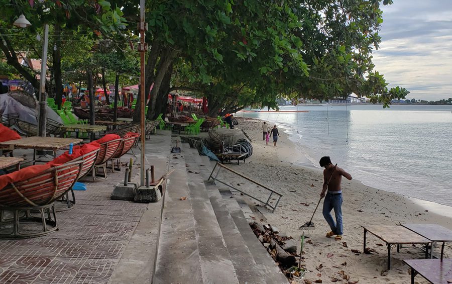 Vendors sweep leaves from the beach and restaurant seating area at Sihanoukville's Independence Beach on November 30, 2020. (Danielle Keeton-Olsen/VOD)