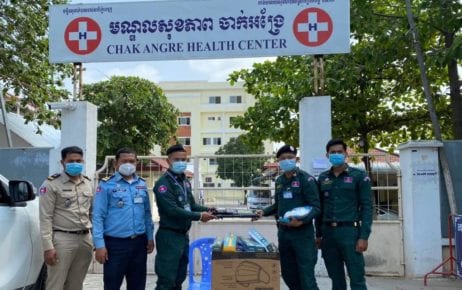 Authorities on duty at Phnom Penh’s Chak Angre Health Center, where Covid-19 patients are treated, pose for a photo in February 2021 while receiving handheld metal detectors and electric-stun batons. (Phnom Penh Police Facebook)