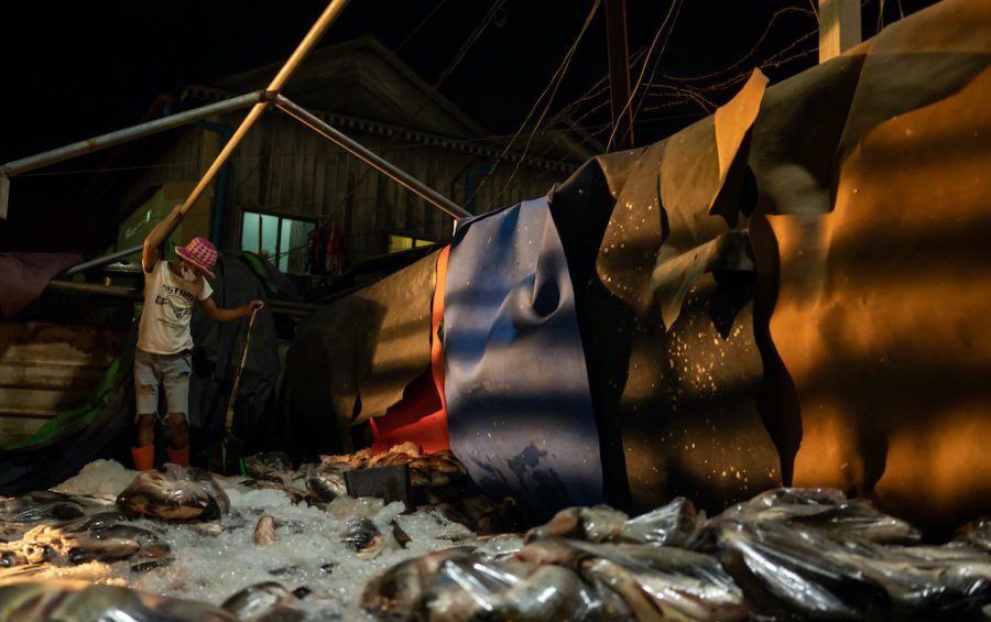 A worker offloads a truck importing fish from Vietnam to Cambodia at Phnom Penh’s Prek Pnov Market. (Andy Ball)