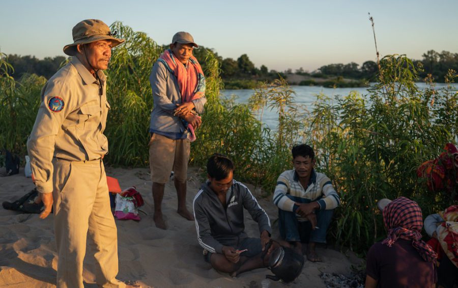 Village chief Sar Kim and community fishery patrollers discuss their patrol plans for the next 24 hours after spending a night camping on a sandbank in the Mekong while on patrol. (Andy Ball)