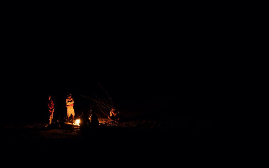 Community fishery patrollers rest around a campfire on a sandbank in the Mekong River after almost 30 hours of back-to-back patrols. (Andy Ball)