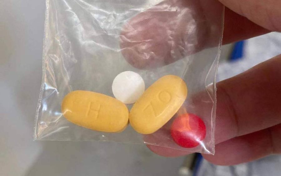 A Covid-19 patient in the Phnom Penh Quarantine Center holds a bag of three medications in early March 2021. (Supplied)