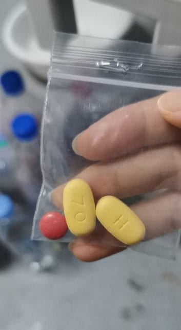 A Covid-19 patient in the Phnom Penh Quarantine Center holds a bag of two medications in early March 2021. (Supplied)