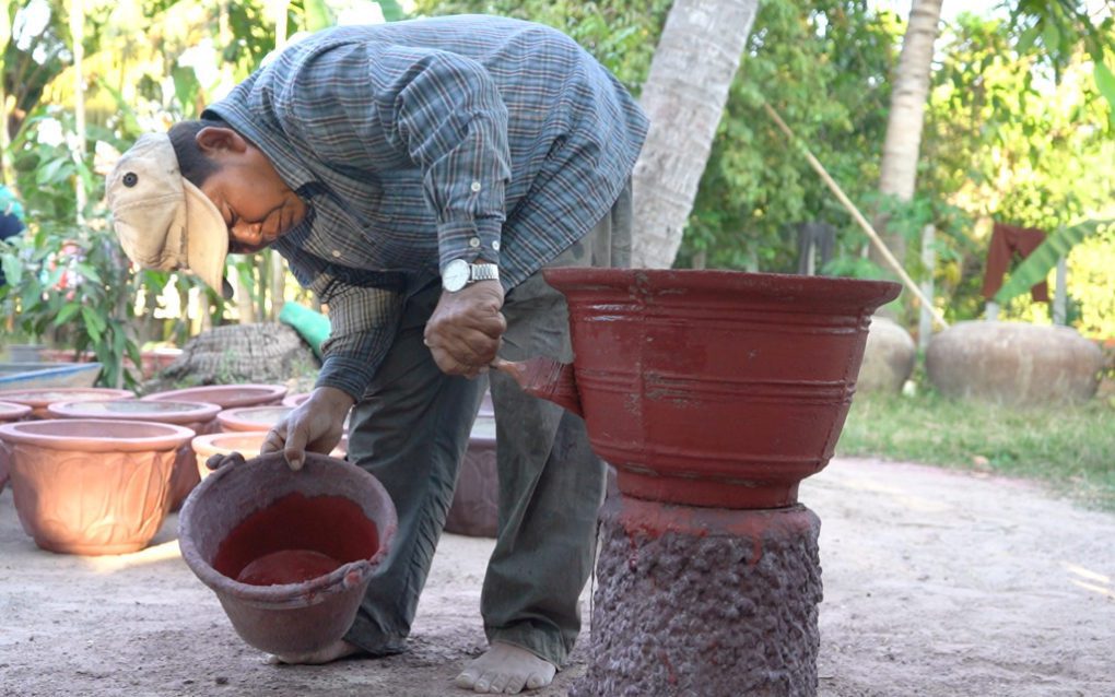 Suong Rang paints a flower pot at his home in Siem Reap province, in January 2021. (Mech Choulay/VOD)