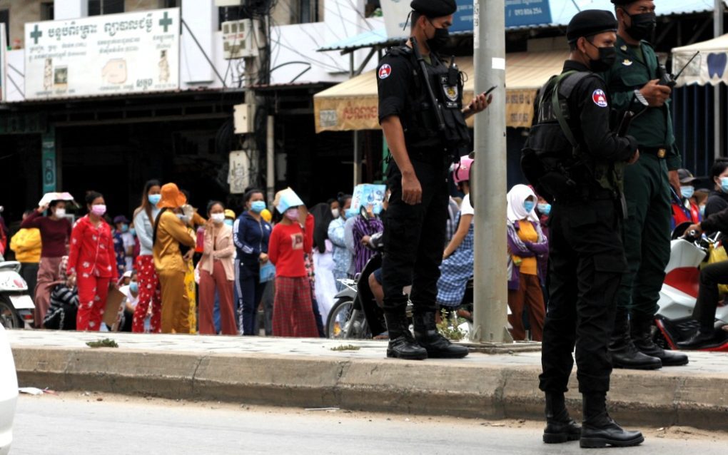 Police officers stand by as Meanchey district residents protest for reduced rents on Phnom Penh’s Veng Sreng Blvd. on May 10, 2021. (Michael Dickison/VOD)