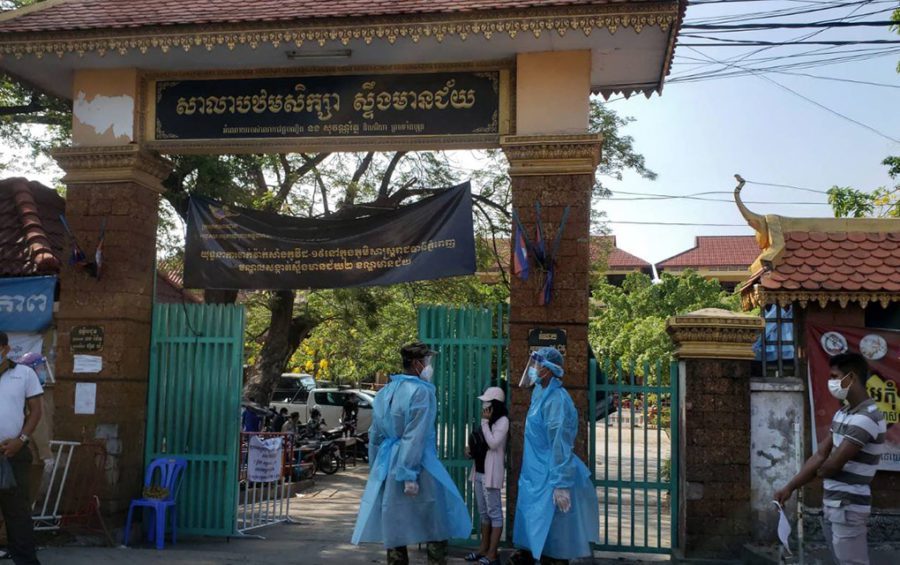 People wear personal protective equipment at the gate of the vaccine station at Phnom Penh's Stung Meanchey primary school on May 11, 2021. (Danielle Keeton-Olsen/VOD)