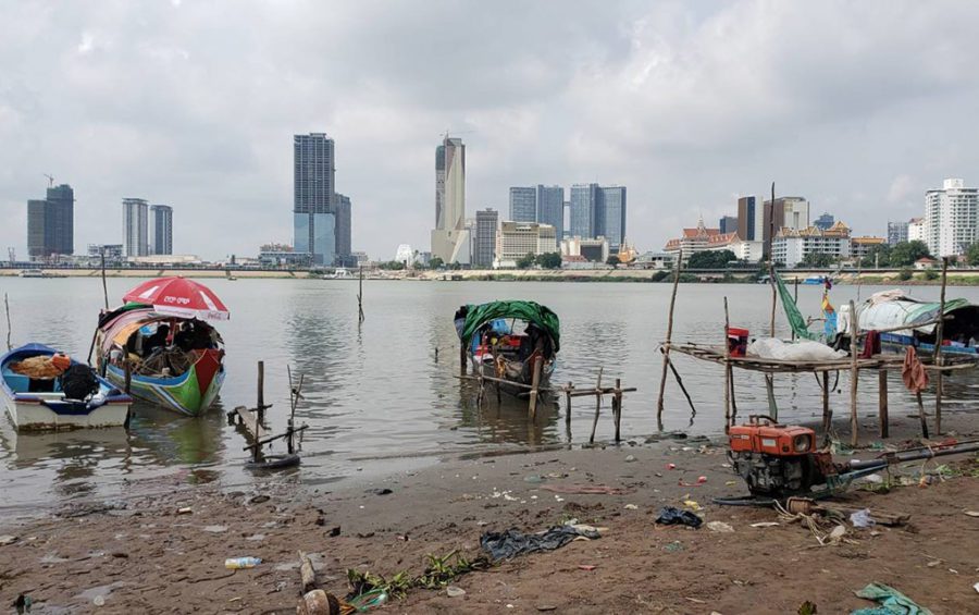 Fishing boats, which serve as homes for about 20 Cham communities, sit on the intersection of the Mekong and Sap rivers fin front of Phnom Penh's skyline on May 18, 2021. (Danielle Keeton-Olsen/VOD)