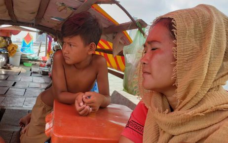 Si Fah and her son sit on their boat and home docked at Phnom Penh's Chroy Changva commune on May 18, 2021. (Danielle Keeton-Olsen/VOD)