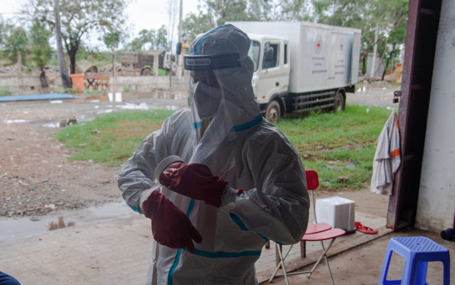 Nguon Sokheng tapes up his personal protective equipment. (Gerald Flynn/VOD)