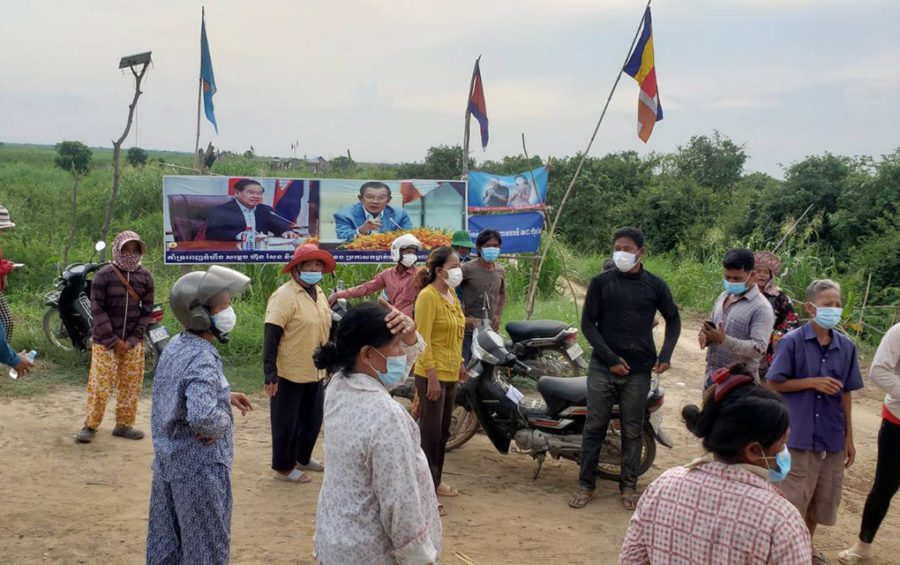 Banteay Dek commune residents gather in front of posters of Prime Minister Hun Sen and Deputy Prime Minister Sar Kheng on farmland that they say the premier awarded them in Kandal province's Kien Svay district on June 2, 2021. (Danielle Keeton-Olsen/VOD)