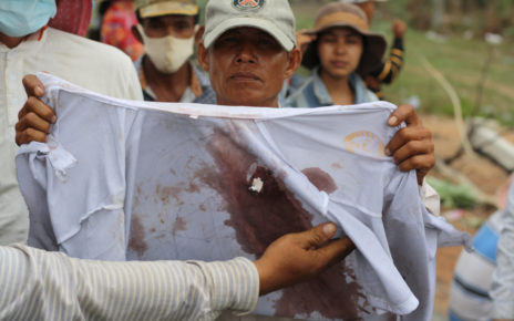 A protester holds up the bloodied shirt of Mom Chantha, who was shot by soldiers amid a land dispute, in Kandal province’s Ang Snuol district on June 3, 2021. (Michael Dickison/VOD)
