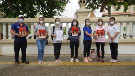 Seven NagaWorld union representatives hold posters in front of the Labor Ministry gate after submitting a petition contesting the company's mass layoffs on June 8, 2021. (Tran Techseng/VOD)