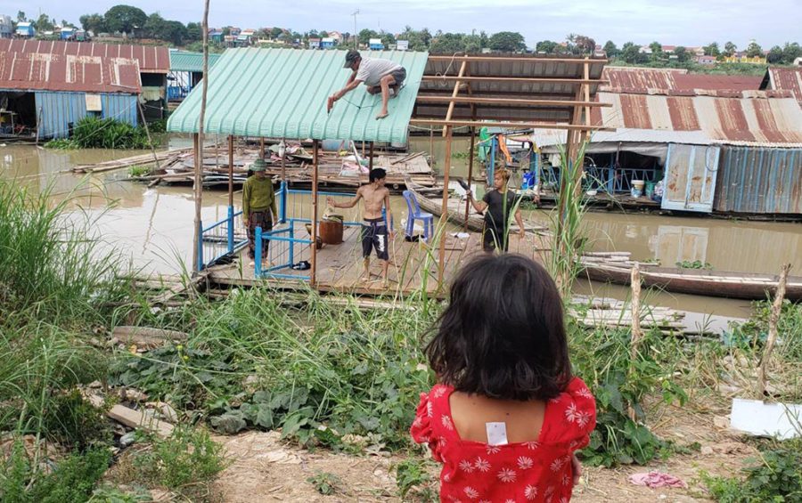 The 11-year-old daughter of Da Lin, 37, watches as volunteers dismantle their floating house in Phnom Penh's Prek Pnov village on June 10, 2021. (Danielle Keeton-Olsen/VOD)