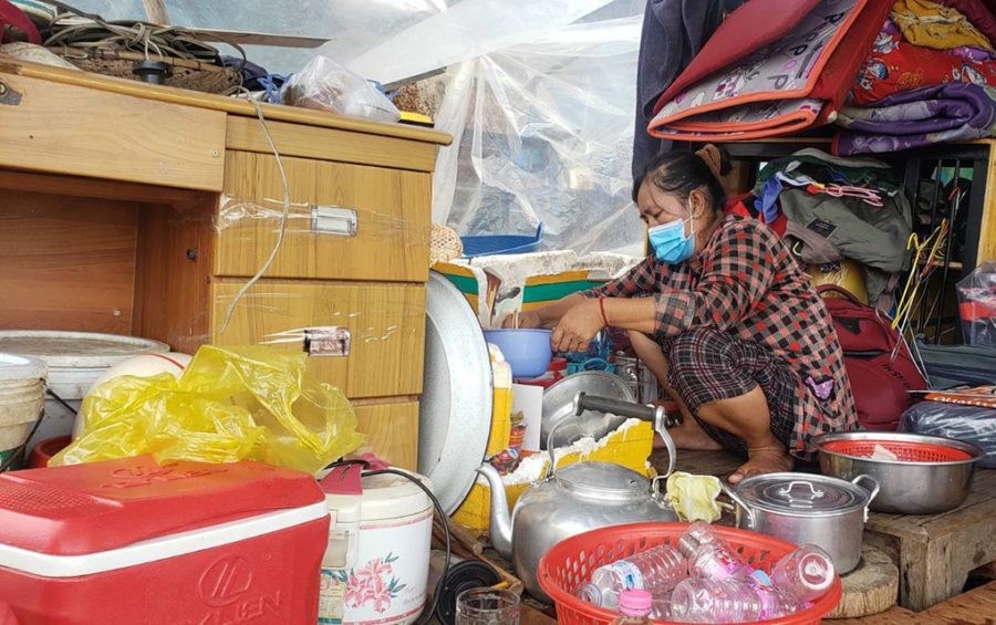 A woman, who recently dismantled her family's floating house, cooks lunch in her temporary shelter in Phnom Penh's Prek Pnov district on June 12, 2021. (Danielle Keeton-Olsen/VOD)