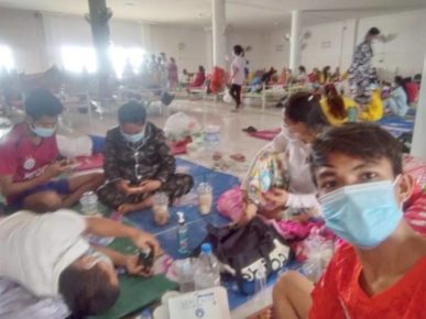 Sambath Sotherith takes a masked selfie with patients in a Covid-19 treatment center in Kampong Cham province in the background during his admission in June. (Supplied)