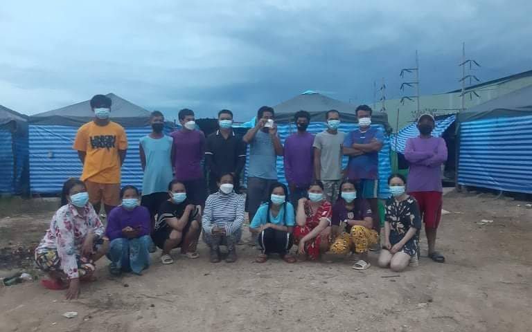 17 masked Cambodian workers pose for a photo at a construction site camp in Thailand's Nakhon Pathom province in July 2021. (Provided by Central)