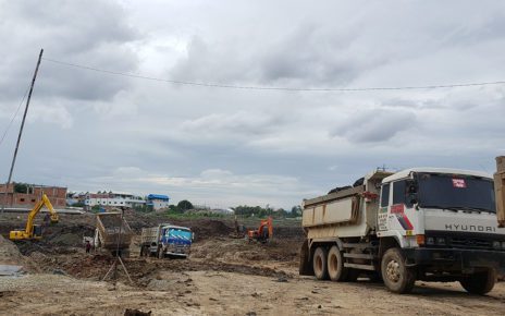 Three dump trucks and three excavators dig out the future reservoir in Boeng Tompun I commune on July 21, 2021. (Danielle Keeton-Olsen/VOD)