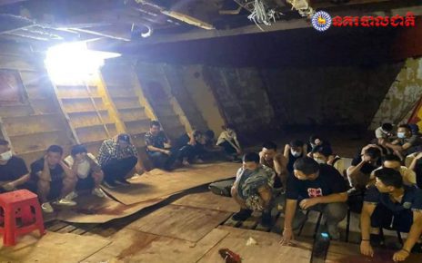More than a dozen men crouch in the hull of a ship, which was carrying 38 Chinese and Cambodian nationals from China until stopped by authorities off the coast of Preah Sihanouk province, in a photo posted by Cambodia's National Police on July 26, 2021.